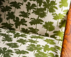 Green palm tree patterned upholstery on wooden furniture. Maison Mermont.