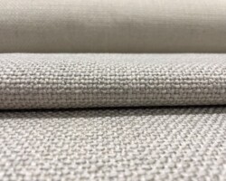 Close-up of beige textured woven fabric for home furnishing. Maison Mermont.
