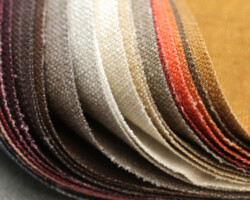 Fabric swatches in warm, earthy tones showcasing upholstery material. Maison Mermont.