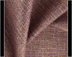 Luxurious woven upholstery fabric in rich brown and purple tones with a textured finish. Maison Mermont.