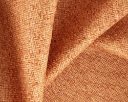 Woven textured orange fabric with intricate patterns, ideal for upholstery. Maison Mermont.