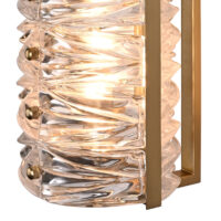 Stylish glass wall light with elegant twisted design and brass accents, ideal for modern interiors. Maison Mermont.