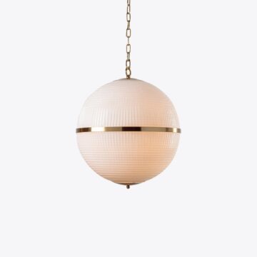 Elegant round pendant light with a textured glass shade and brass accents, perfect for modern interiors. Maison Mermont.