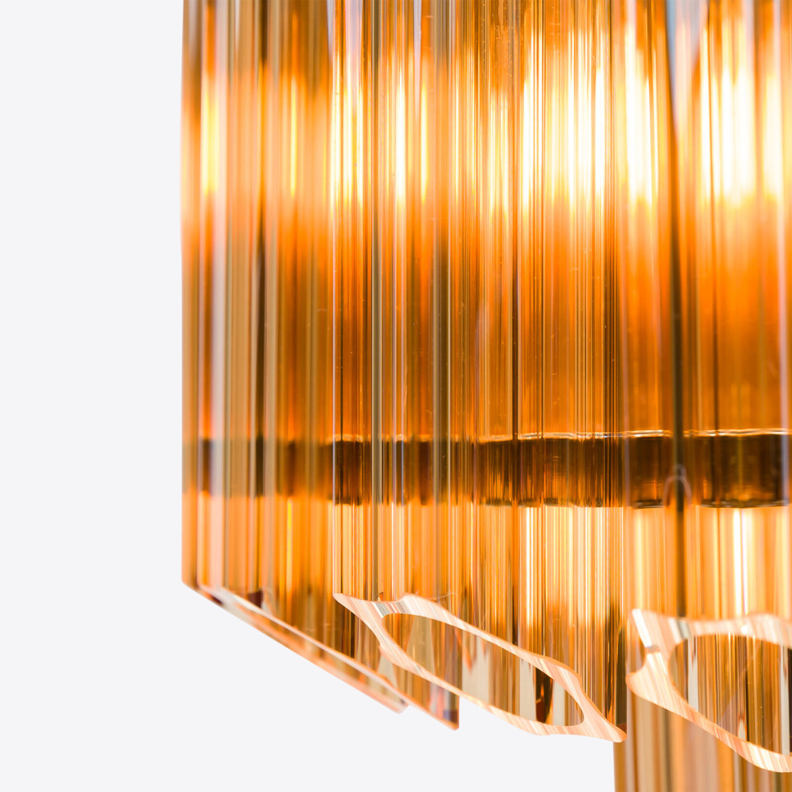 Amber-Small-Celesta-Chandelier Golden pendant light with vertical glass panels, emitting a warm glow. Maison Mermont.