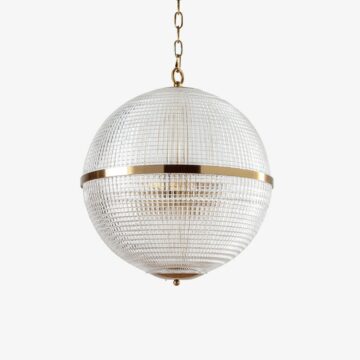 Stylish round pendant light with a textured glass design and gold accents, perfect for modern interiors. Maison Mermont.