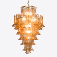 Amber Corolla Large Chandelier Elegant glass chandelier with tiered design, emitting warm light for a luxurious ambiance. Maison Mermont.