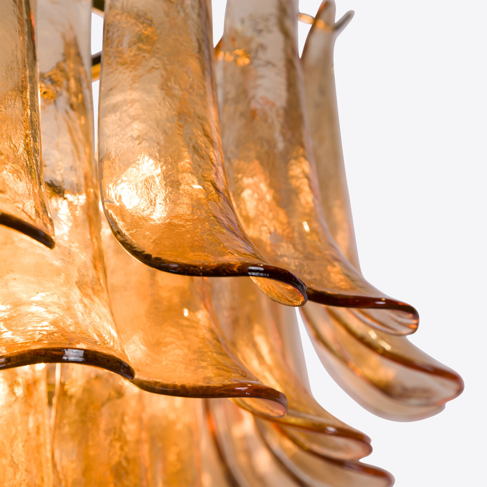 Amber Corolla Large Chandelier Elegant amber glass chandelier with flowing, organic shapes illuminating a warm ambiance. Maison Mermont.