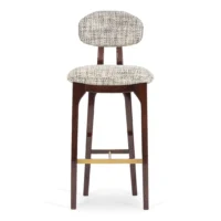 maison-mermont-silhouette-bar-stool-mix-02-translucent-dark-brown-oxidized-brushed-brass-01-insidherland Elegant upholstered bar stool with a curved backrest and wooden legs, perfect for modern interiors. Maison Mermont.