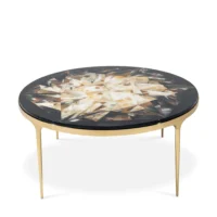 Elegant round coffee table with a patterned top and gold legs, perfect for modern interiors. Maison Mermont.