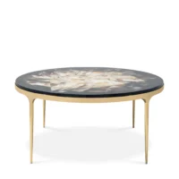 Elegant round coffee table with a unique inlaid top and gold legs, perfect for modern living spaces. Maison Mermont.