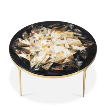 Elegant round coffee table with a geometric inlay design in earthy tones and sleek gold legs. Maison Mermont.