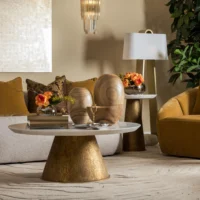 Maison Mermont - Zain Coffee Table Stylish living room featuring a gold accent coffee table, wooden decor, and floral arrangements. Maison Mermont.