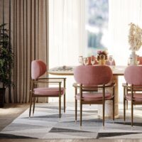 Elegant dining room featuring pink velvet chairs around a modern round table with floral decor. Maison Mermont.