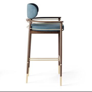 Elegant wooden bar stool with a soft blue cushion and gold accents, perfect for modern interiors. Maison Mermont.