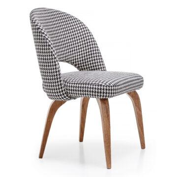 Stylish upholstered chair with a modern houndstooth pattern and wooden legs, perfect for contemporary interiors. Maison Mermont.
