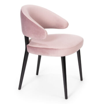 Stylish pink velvet chair with sleek black legs, perfect for modern interiors. Ideal for dining or accent seating. Maison Mermont.