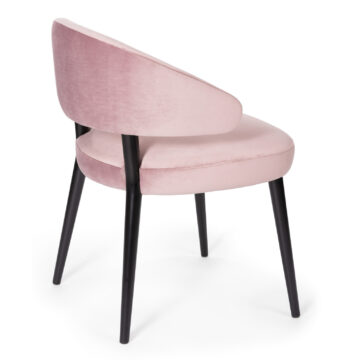Stylish pink velvet chair with sleek black legs, perfect for modern interiors. Ideal for dining or accent seating. Maison Mermont.