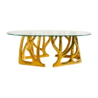 Elegant oval glass coffee table with a unique gold nature-inspired base design. Perfect for modern interiors. Maison Mermont.