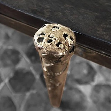 Handcrafted metal coffee table with bronze textured legs, showcasing modern artisanal design. Maison Mermont